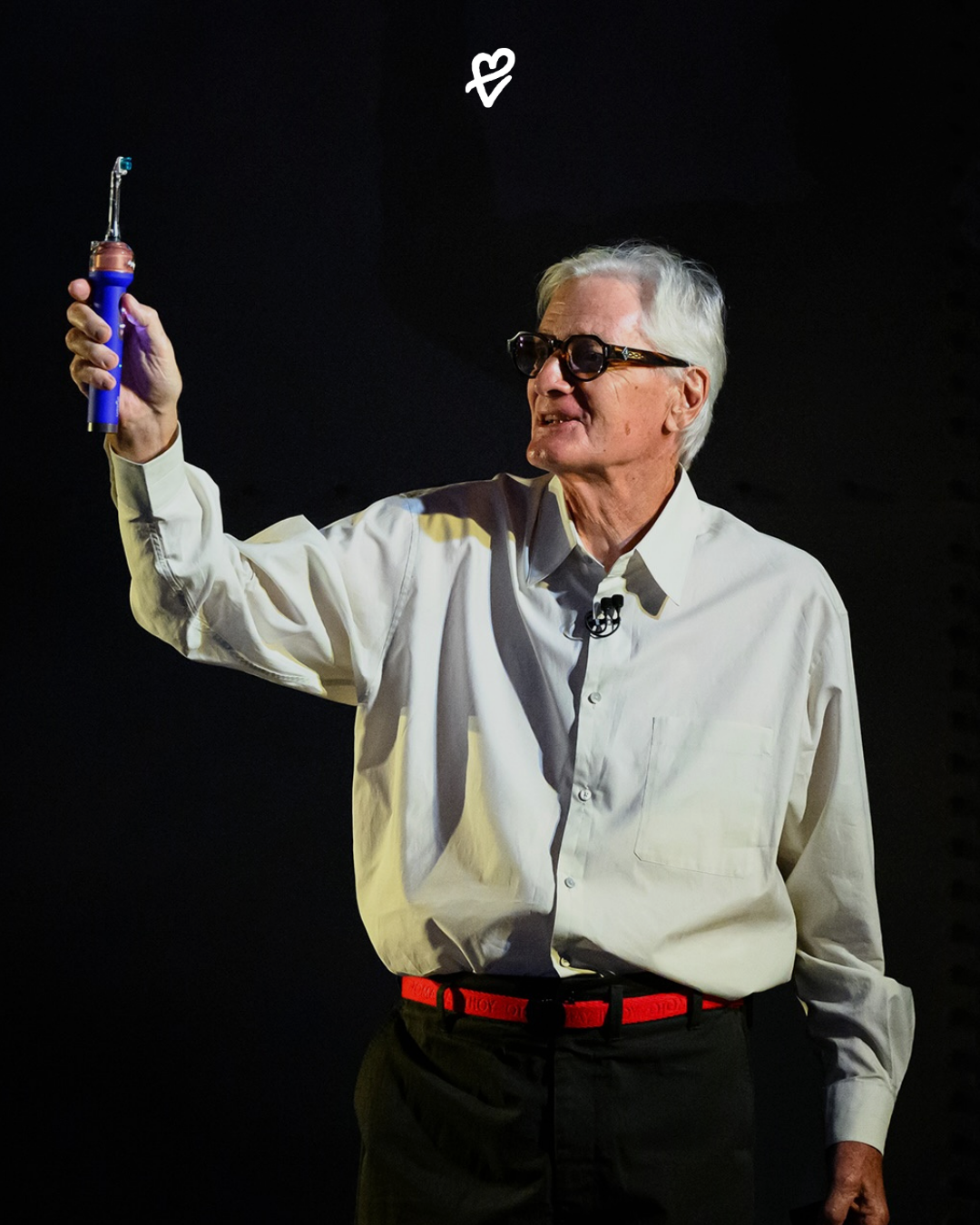 Dyson CameraJet elektrikli diş fırçasını elinde tutan model ve cihazın kameralı fırça başlığı.