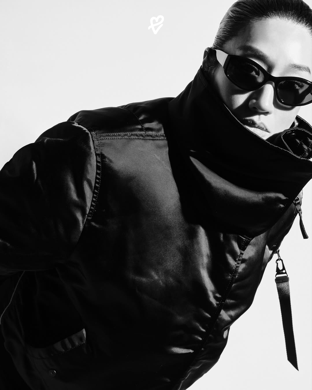 Peggy Gou x Alpha Industries kapsül koleksiyonundan COCOON BOMBER ceket ve MINI WRAP SKIRT kombinli bir şehir silueti.