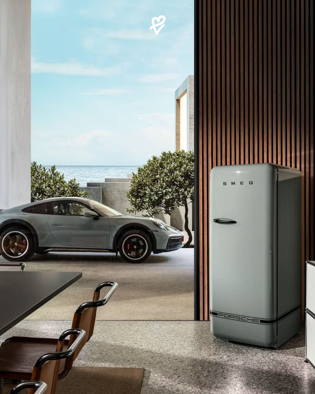 Porsche x Smeg iş birliğiyle üretilmiş kırmızı FAB28 buzdolabı ve mutfak aletleri, modern bir mutfakta sergileniyor.