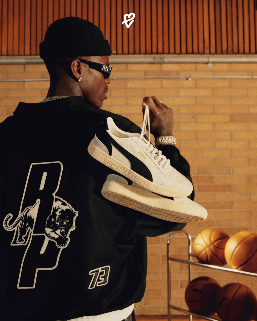 Represent x PUMA Hoops koleksiyonundan Majesty ve All-Pro Nitro 2 modelleri ile siyah Coach Ceket kombinlenmiş bir şehir stili görünümü.