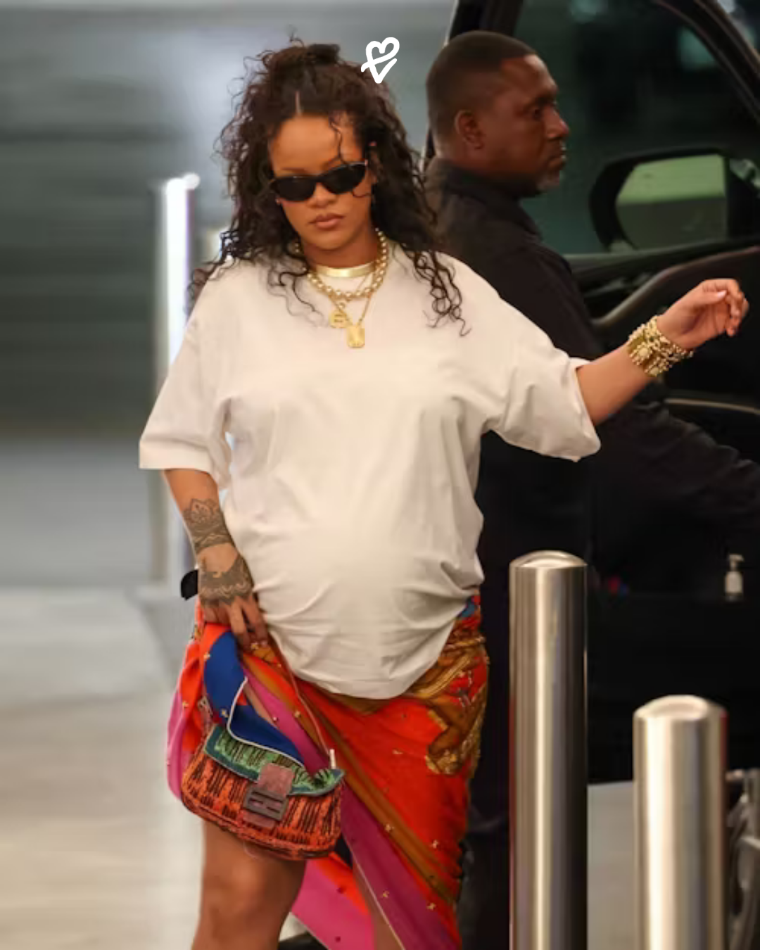 Rihanna beyaz tişört, flip-flop ve vintage çanta kombiniyle LA sokak stilinde.