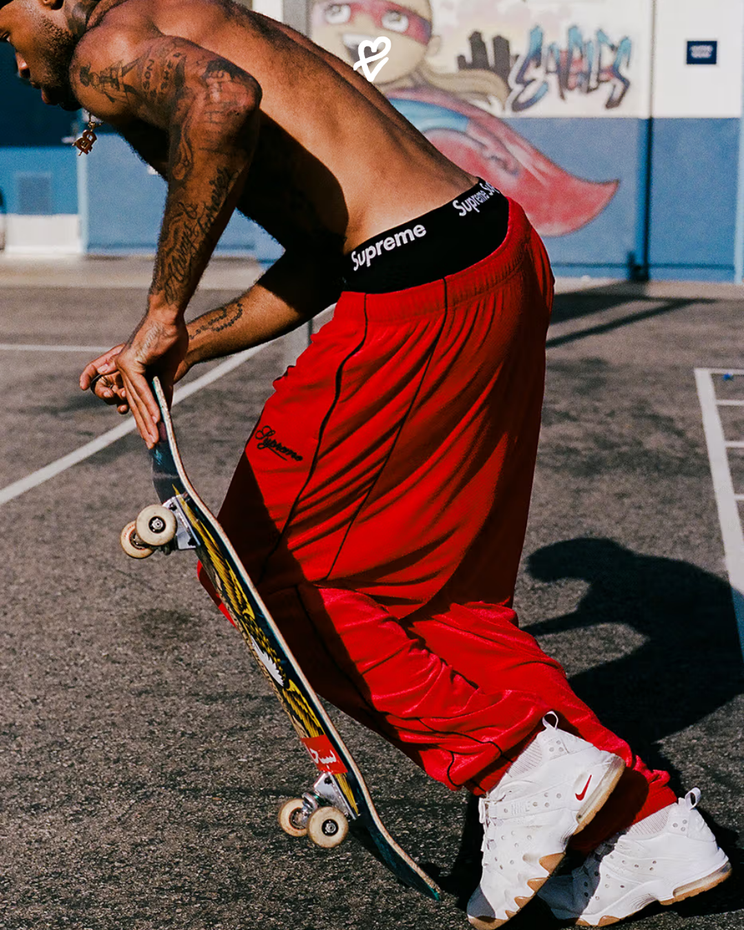 Supreme x Nike SB Air Max 2 CB '94 Low modeli, kaykay tahtası üzerinde giyilen, siyah detaylı low-top sneaker