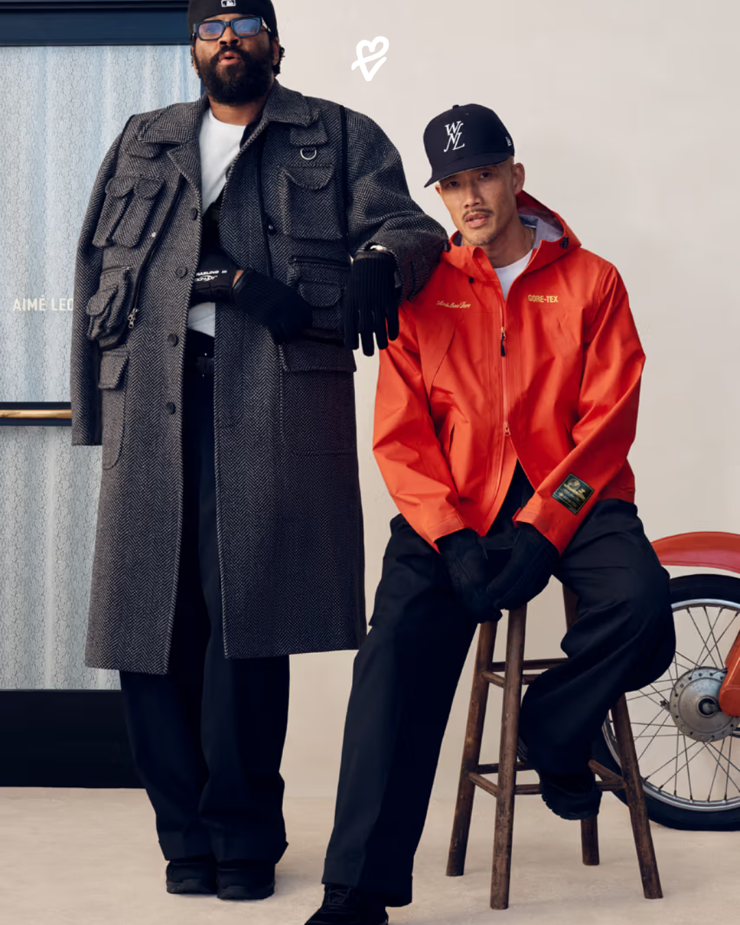 Aimé Leon Dore FW25 koleksiyonundan bej tonlarında oversize bir paltoyla New York sokaklarında poz veren model.