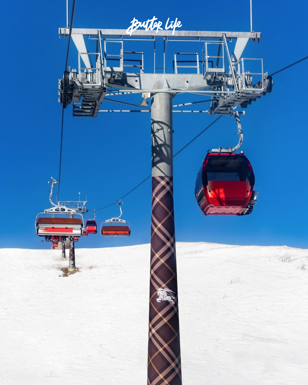 Burberry'nin Chongli kayak merkezinde konumlanan pop-up alanı, cam cepheli modern mimarisi ve Burberry Check desenli kayak teleferikleriyle dikkat çekiyor.