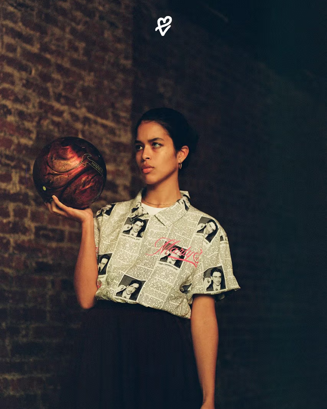 Golf Wang x Marty Supreme koleksiyonundan 1950’ler ilhamlı bowling gömlekli genç bir model, retro masa tenisi masası önünde poz veriyor