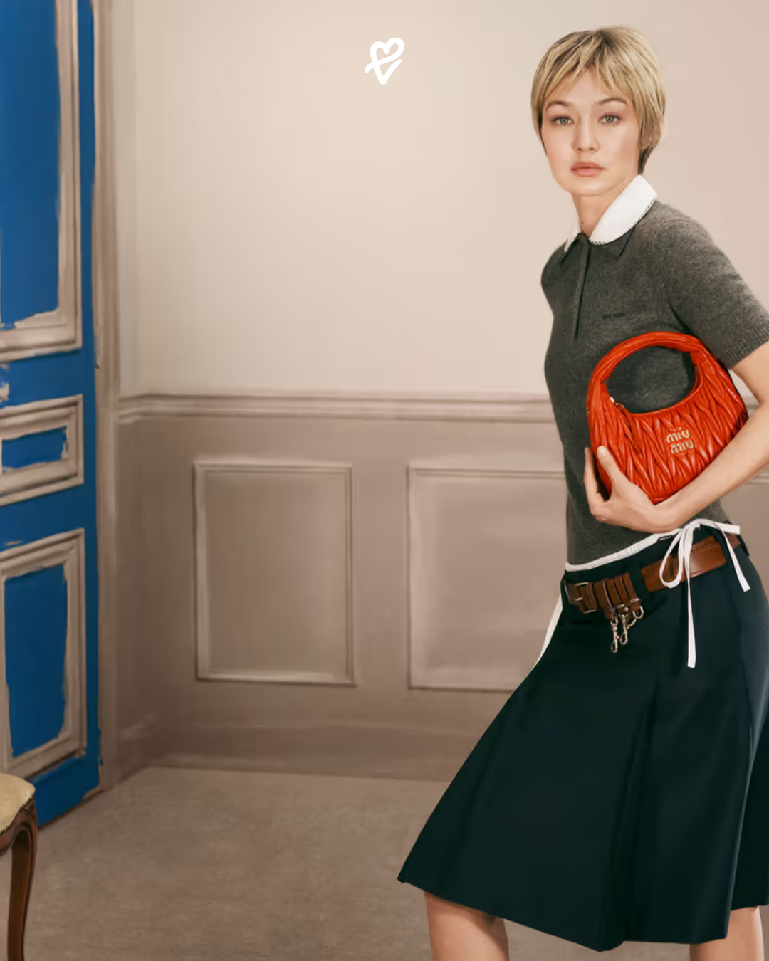 Gigi Hadid, Miu Miu kampanyasında Arcadie çanta ve polo yaka üst ile beyaz tonlu bir odada poz veriyor.