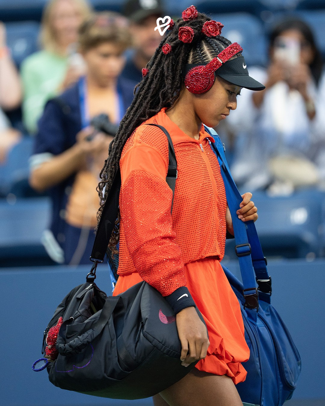 Naomi Osaka’nın kırmızı kristalli Labubu aksesuarı, çantasına takılı mavi tenis raketiyle gösterişli bir kontrast oluşturuyor.