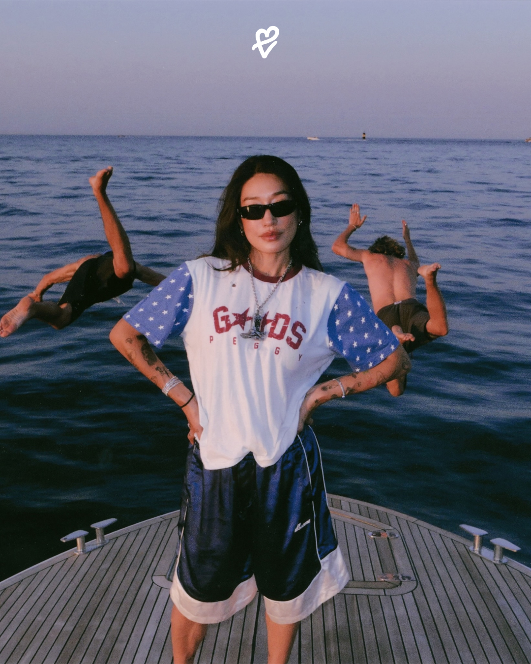 Peggy Gou'nun boynunda sergilediği, kovboy botu formunda tasarlanmış ve içinde USB bellek barındıran 925 ayar gümüş TwoJeys x Peggy Goods charm kolye ucu.