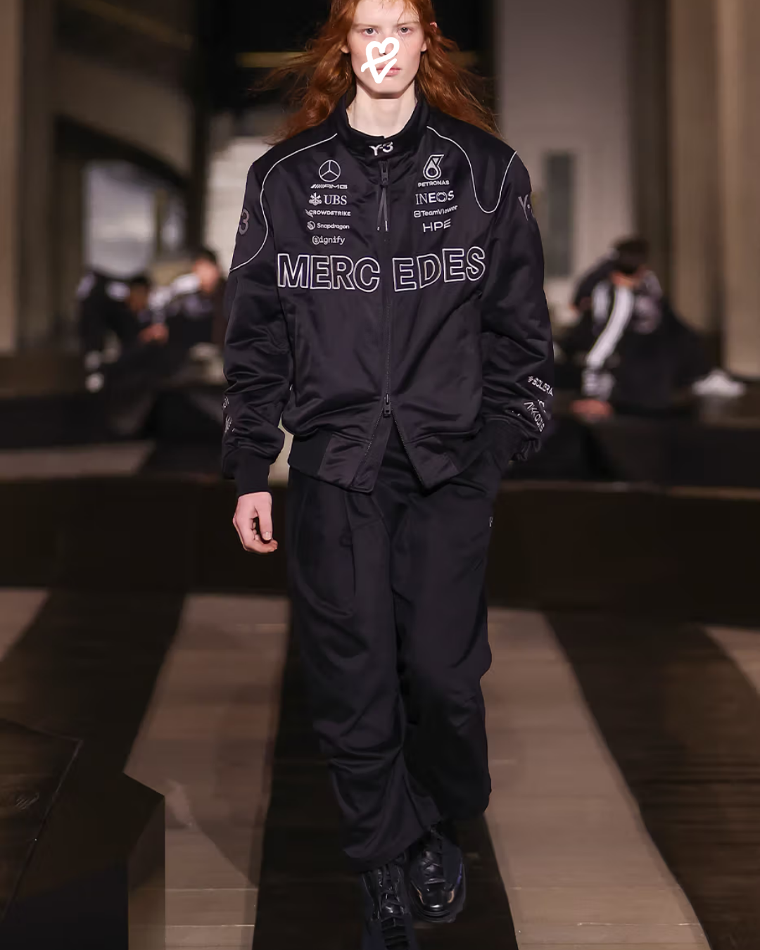 Y-3 Sonbahar/Kış 2026 defilesinden Mercedes iş birliğine ait siyah tonlarındaki aerodinamik ceket tasarımı